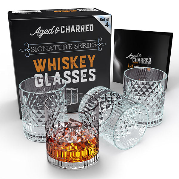 Set of four crystalline whiskey glasses displayed alongside their gift ready box and recipe book