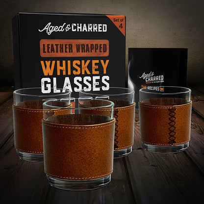 A set of four brown leather wrapped rocks glasses with a crystalline finish packaged in a gift-ready box including top cocktail recipes