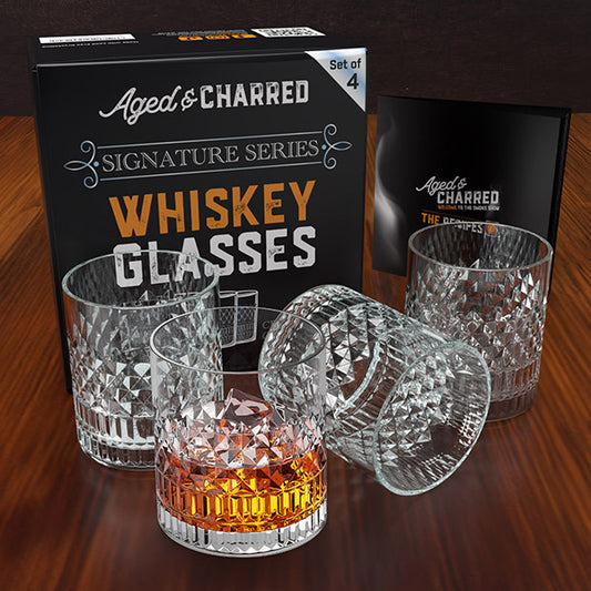Set of four crystalline whiskey glasses displayed alongside their gift ready box and recipe book